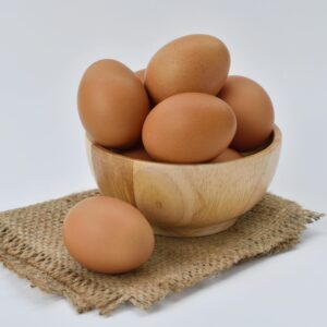 Brown Eggs on Brown Wooden Bowl on Beige Knit Textile